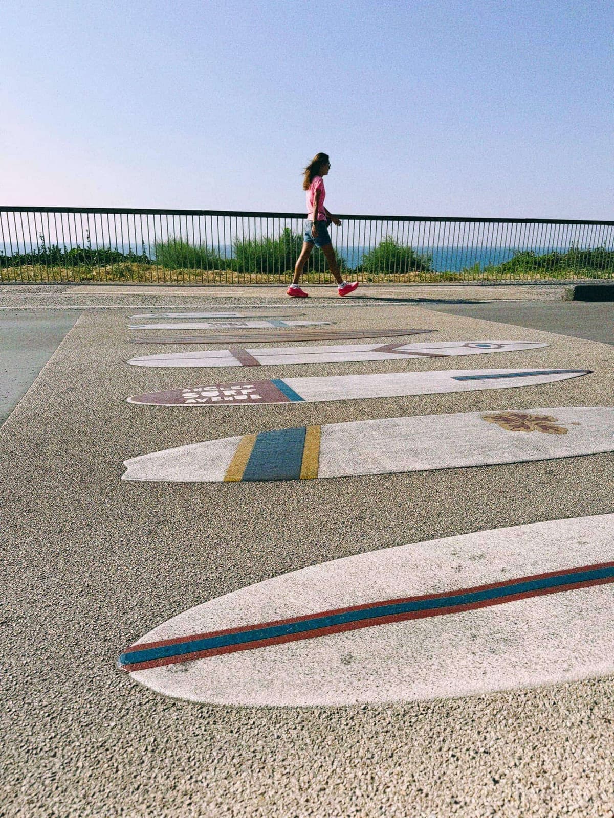 Surfboards inlaid in the promenade, the town wearing its obsession on the ground