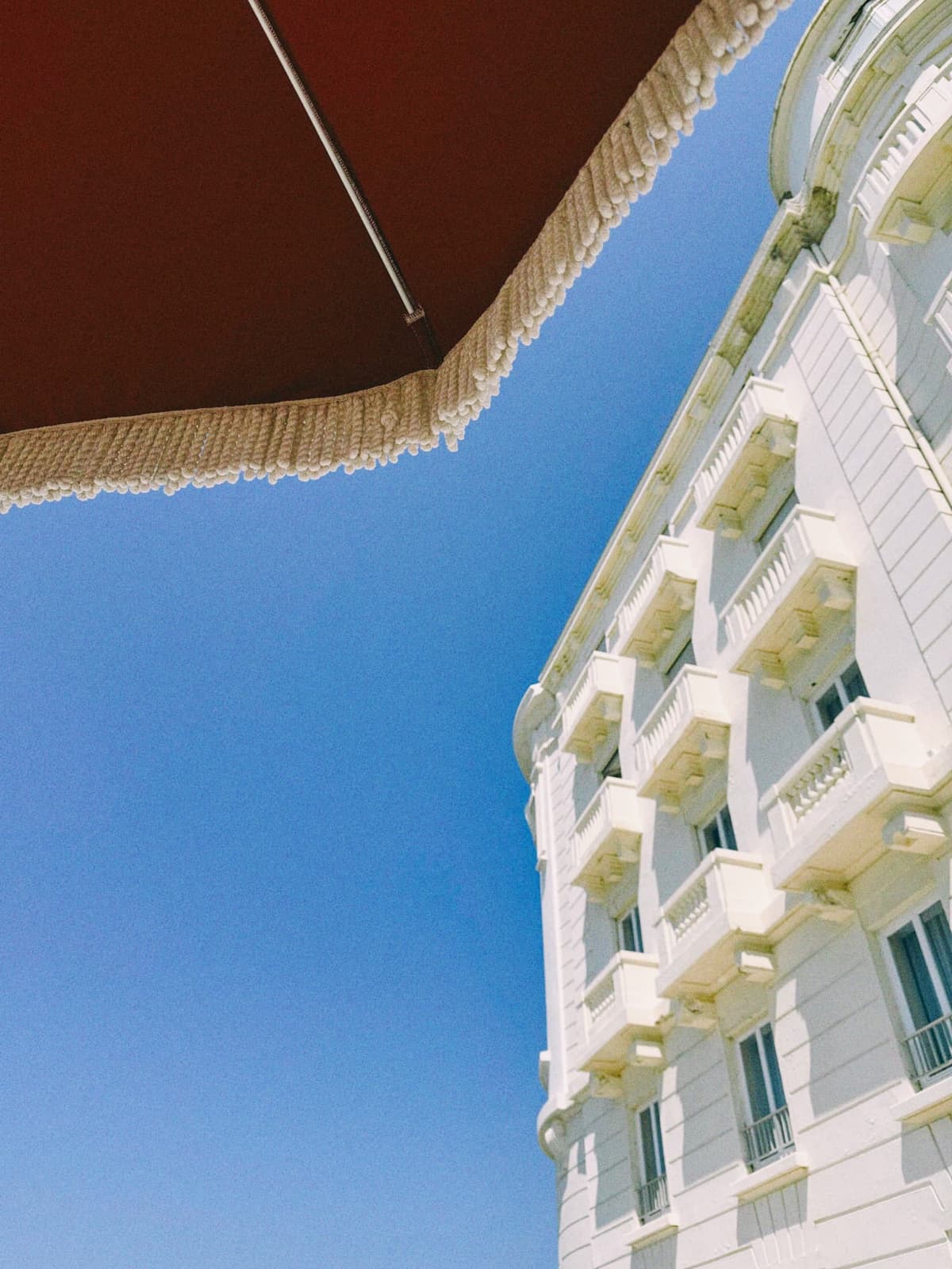 Wedding-cake balconies climbing into a hard blue sky