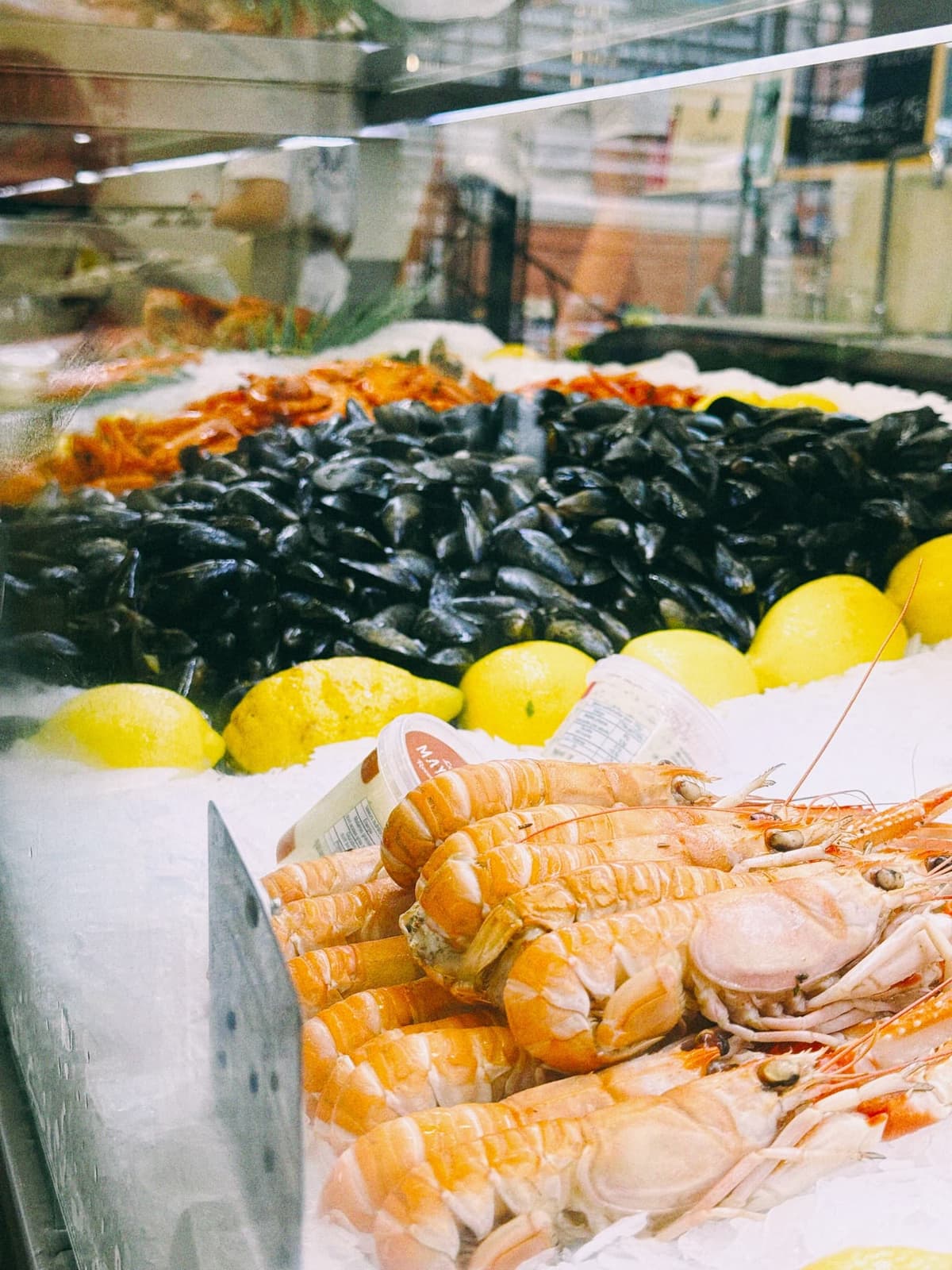 Langoustines and mussels stacked on ice, lemons standing by