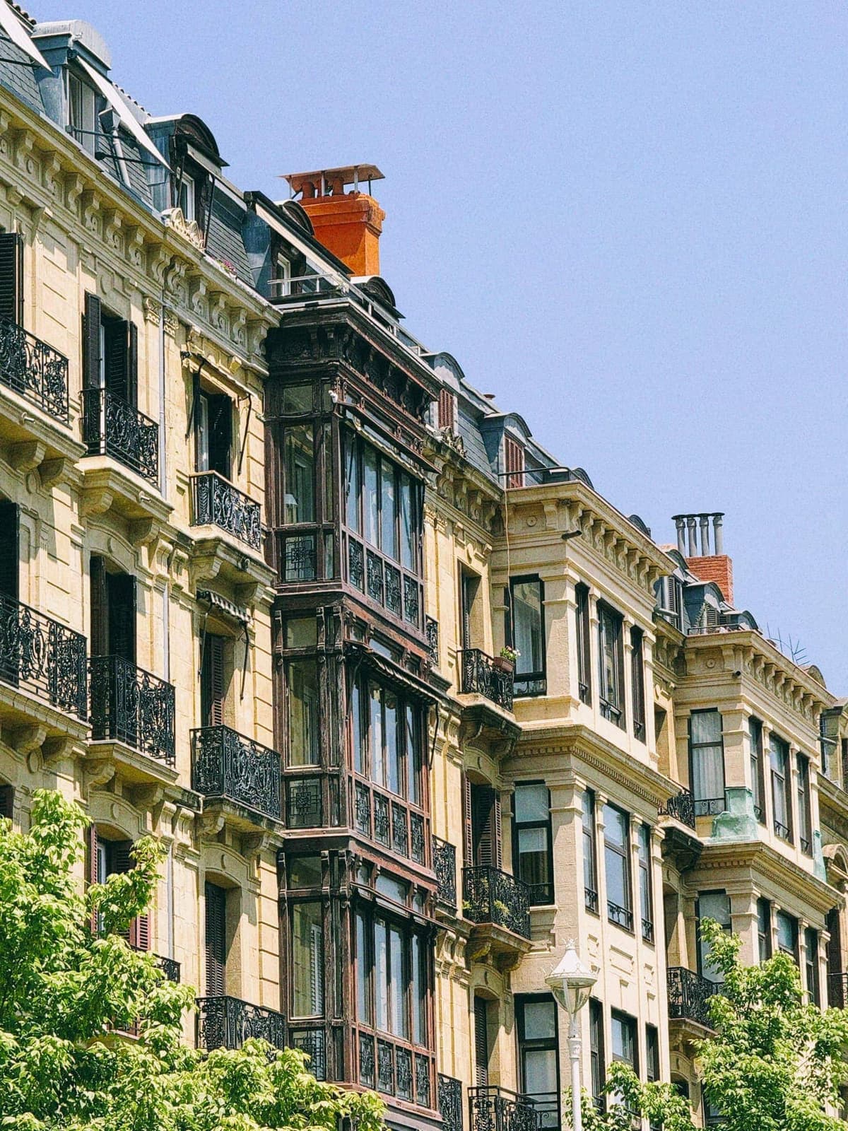 Bay windows stacked five storeys high, one orange chimney breaking rank