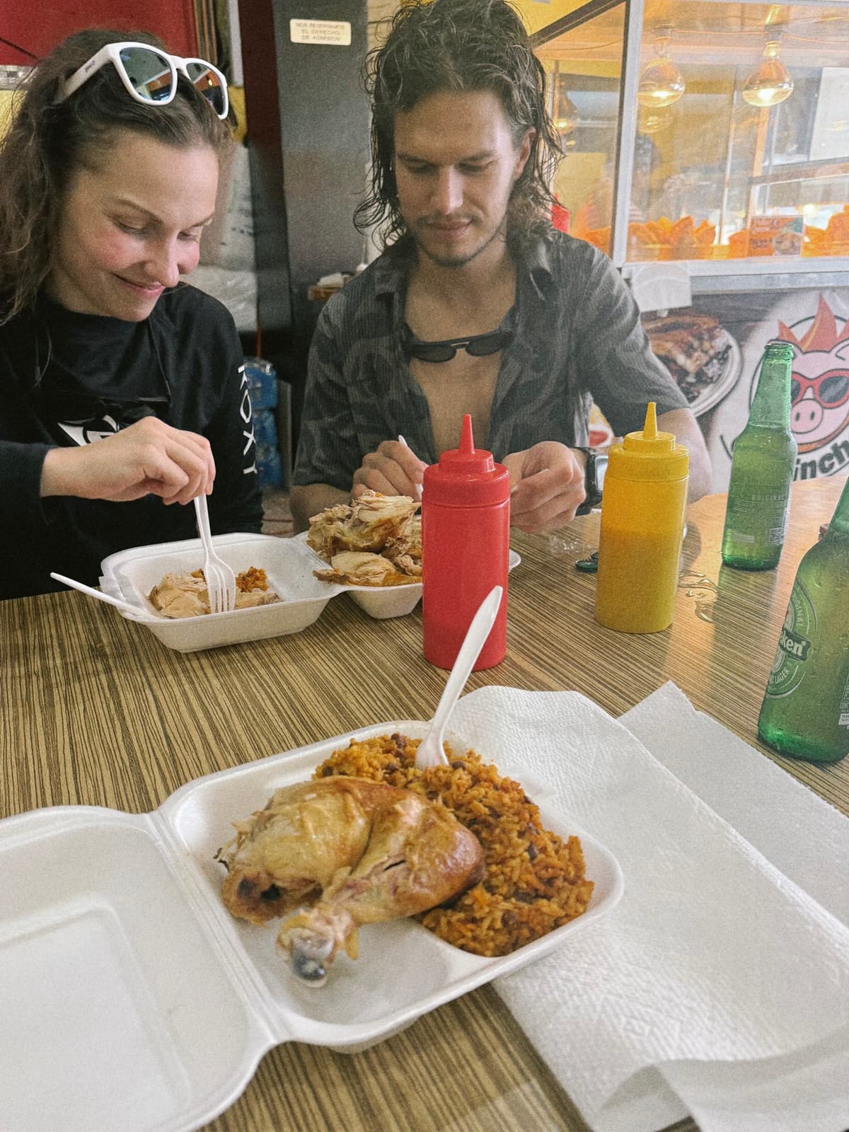 Rice, chicken, and squeeze bottles at a roadside lunch table