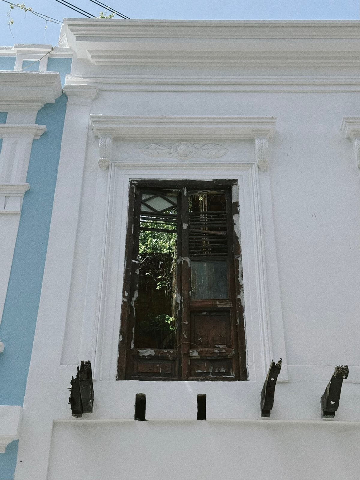 A weathered wooden door set into a crisp white colonial facade
